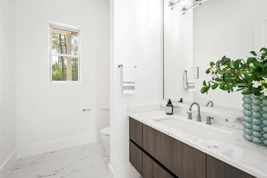 An elegant powder bathroom featuring a quartzite countertop, Rohl polished nickel faucet and coordinating hardware, complemented by a sleek Moen smart toilet—tucked strategically off the foyer. An elegant powder bathroom featuring a quartzite countertop, Rohl polished nickel faucet and coordinating hardware, complemented by a sleek Moen smart toilet—tucked strategically off the foyer.