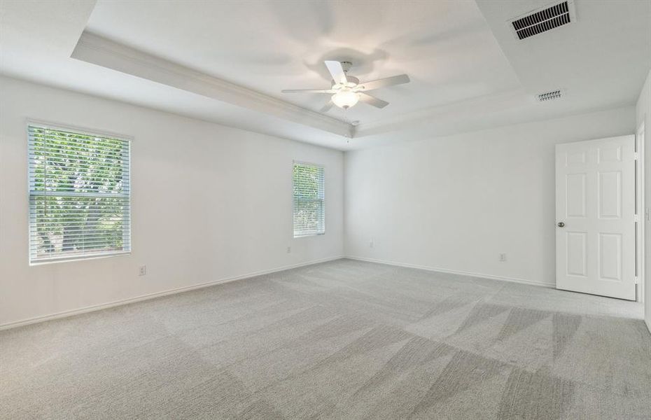 Elegant owner's suite with tray ceiling *real home pictured