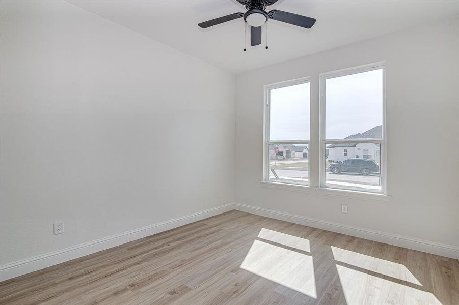 Empty room with light wood-style floors and ceiling fan
