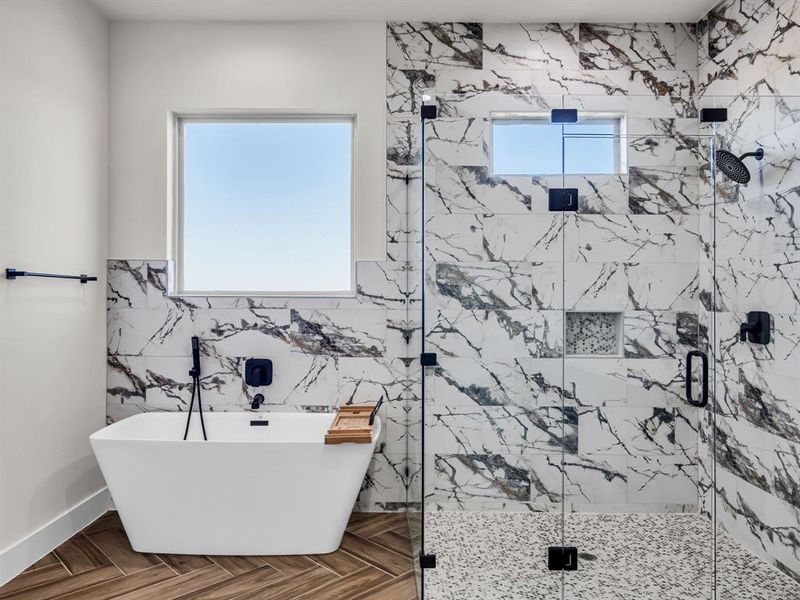 Bathroom featuring tile walls, plus walk in shower, and plenty of natural light