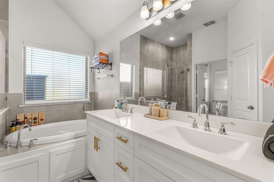 Bathroom with plus walk in shower, vanity, and vaulted ceiling