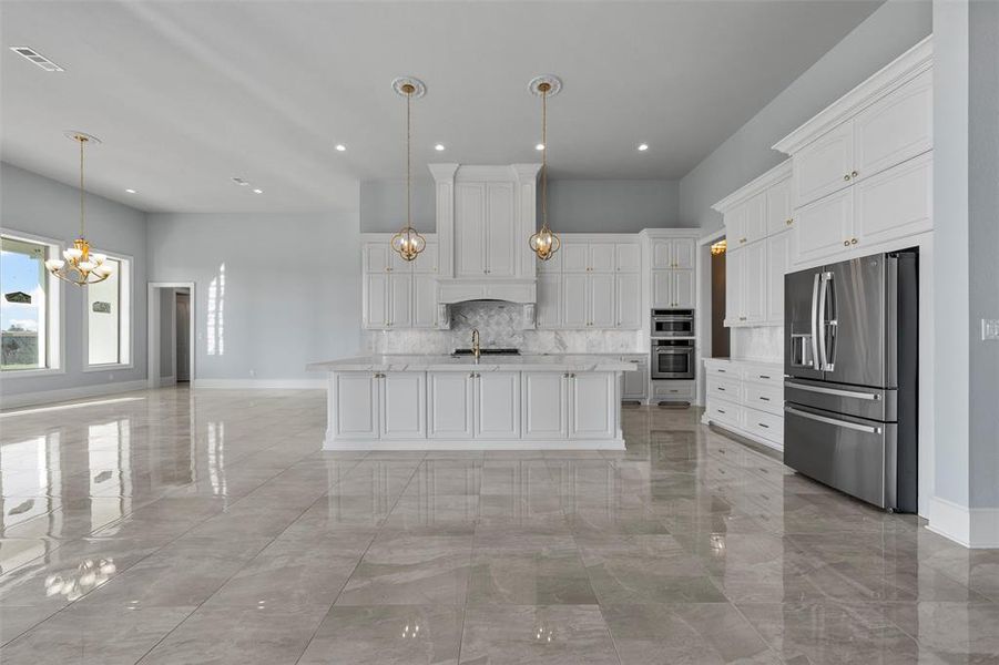 Kitchen with backsplash, stainless steel appliances, a chandelier, white cabinets, and recessed lighting Kitchen with backsplash, stainless steel appliances, a chandelier, white cabinets, and recessed lighting