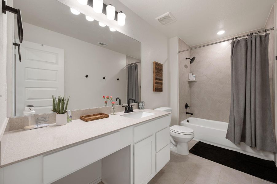 Bathroom featuring vanity, shower / tub combo with curtain, light tile patterned floors, and recessed lighting