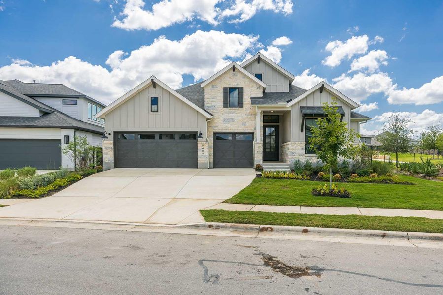 View of front of property featuring board and batten siding, driveway, stone siding, a front lawn, and a shingled roof View of front of property featuring board and batten siding, driveway, stone siding, a front lawn, and a shingled roof