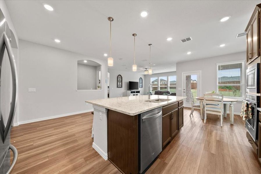 Kitchen with sink, luxury vinyl flooring, flooring, ceiling fan, an island with sink, and decorative recess light fixtures.