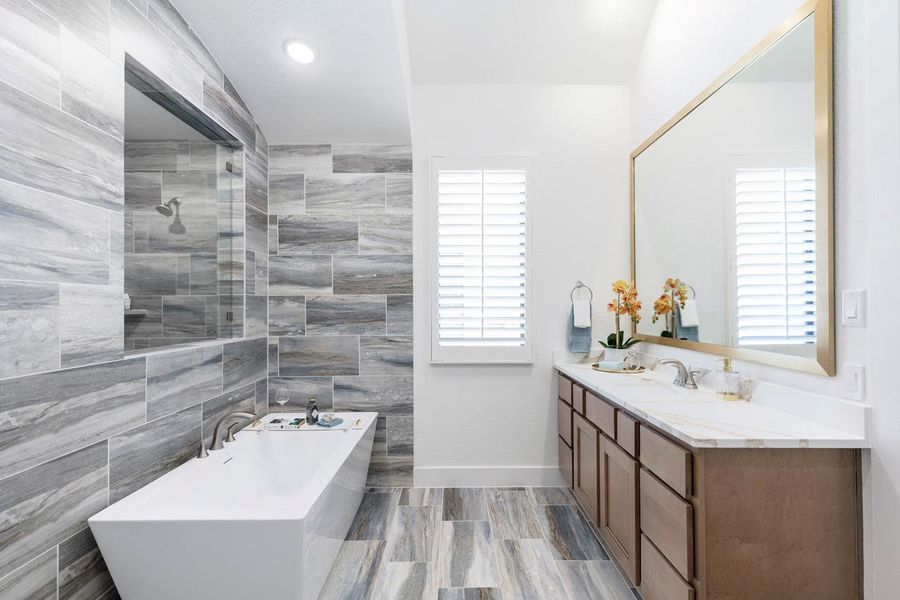 Bathroom featuring vanity, a freestanding tub, baseboards, and tiled shower Bathroom featuring vanity, a freestanding tub, baseboards, and tiled shower