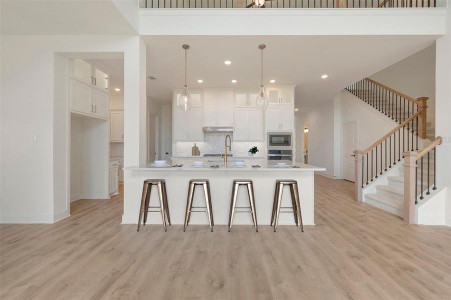 Open-concept living area featuring light wood-finish flooring