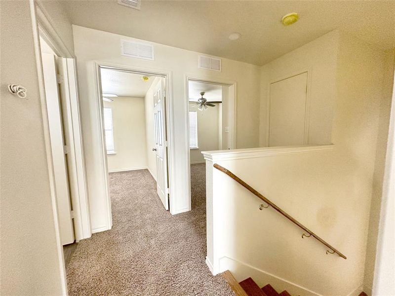 Corridor with an upstairs landing and carpet floors