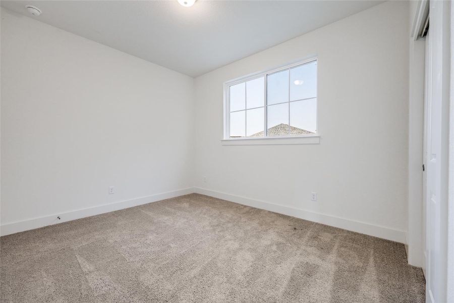 Unfurnished bedroom featuring light carpet and baseboards Unfurnished bedroom featuring light carpet and baseboards