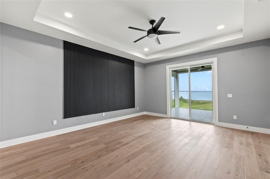 Primary Suite One - Downstairs - Wake up to open water views from private bedroom retreats with private patio access, wood floors, trace ceilings, large glass doors.