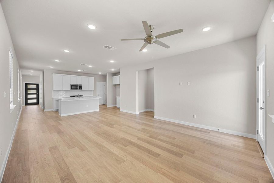 A streamlined open-concept space features warm wood flooring and recessed lighting. A streamlined open-concept space features warm wood flooring and recessed lighting.