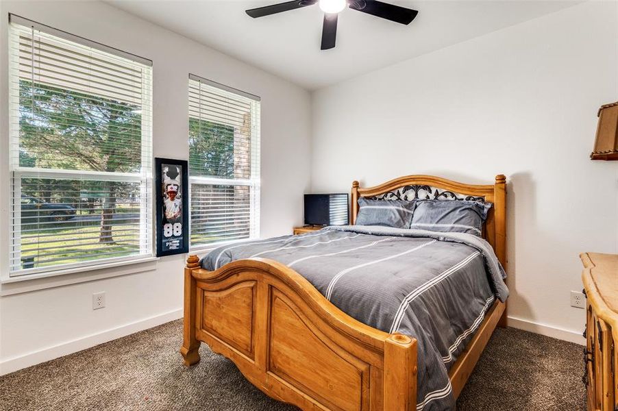 Bedroom with dark carpet and a ceiling fan