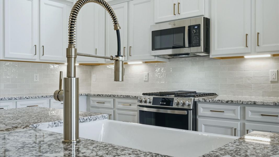 Superior craftsmanship shines in this modern kitchen with granite countertops and open flow