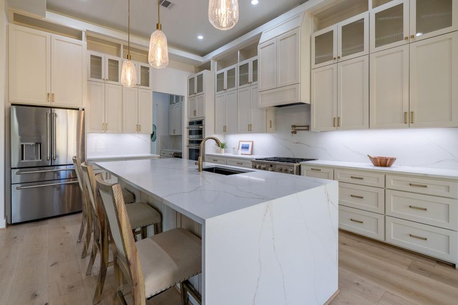 Designer kitchen with oversized island, custom cabinetry, premium appliances, and an open layout ideal for entertaining.
