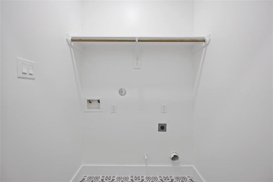 The spacious utility closet has shelving built-in to store cleaning supplies and hang special clothing to dry.