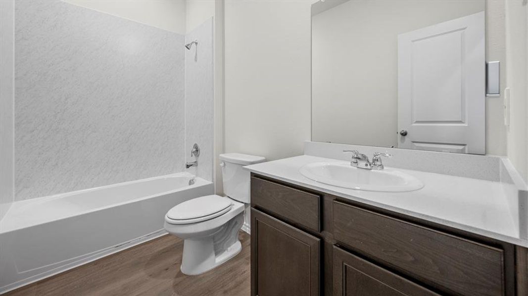 Full bathroom with vanity, washtub / shower combination, and dark wood-style floors
