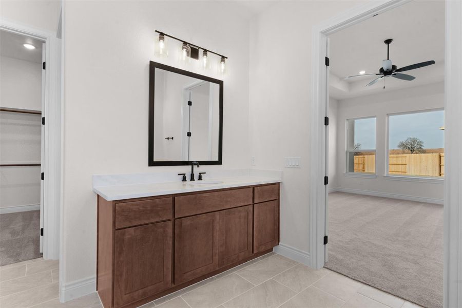 Bathroom with vanity, light carpet, recessed lighting, ceiling fan, and a spacious closet