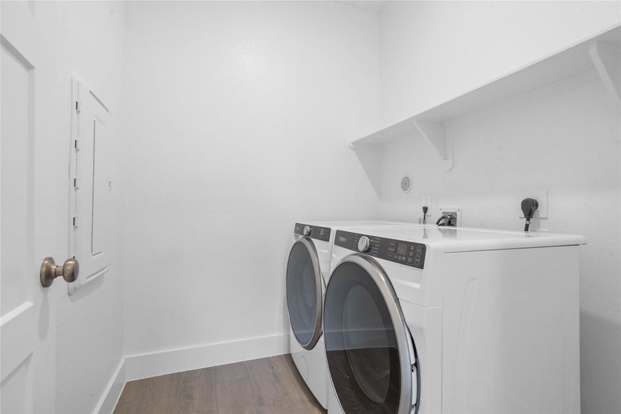 This dedicated laundry room comes equipped with a washer and dryer set, ready for immediate use. This laundry room is conveniently located near the primary bedroom.