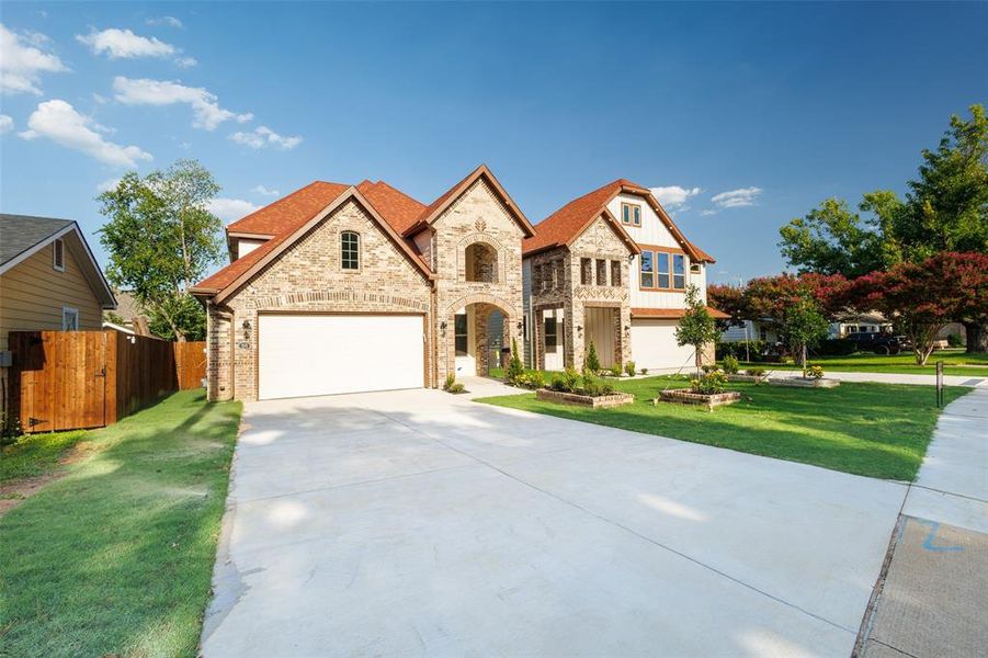 View of front of house with a garage, driveway, a shingled roof, stone siding, and board and batten siding