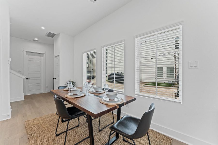 This beautifully designed dining area offers ample space for a full-size dining table, making it ideal for hosting gatherings or enjoying everyday meals in comfort. Surrounded by large windows, the room is bathed in natural light throughout the day, creating a warm and inviting atmosphere. Its seamless integration with the open-concept kitchen and living space enhances flow and functionality, while offering picturesque views and a sense of connection to the outdoors.