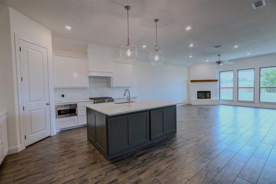 Kitchen with wall oven, premium range hood, ceiling fan, dark wood finished floors, and white cabinets