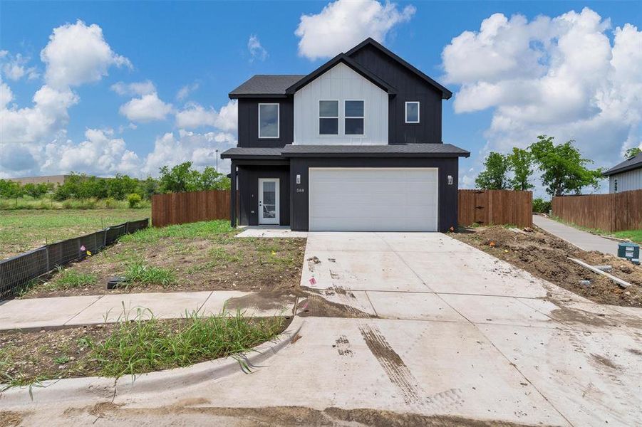 View of front facade featuring a garage, driveway, and board and batten siding