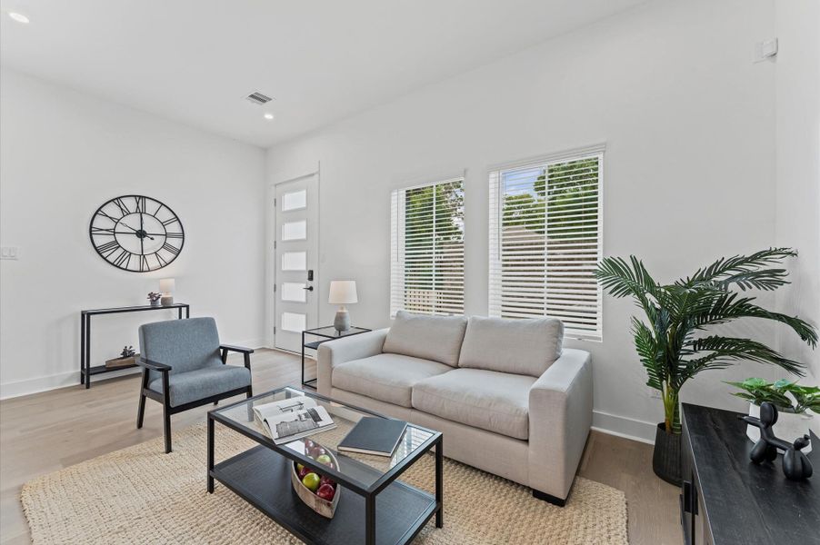 This stunning living room offers an abundance of natural light, thanks to its expansive windows that frame the space with warmth and openness. The airy layout flows effortlessly into a sleek, modern kitchen and a stylish dining area, creating a seamless open-concept design perfect for entertaining or relaxing. With high ceilings, elegant finishes, and panoramic views, this main living space is the heart of the home... inviting, functional, and beautifully connected.