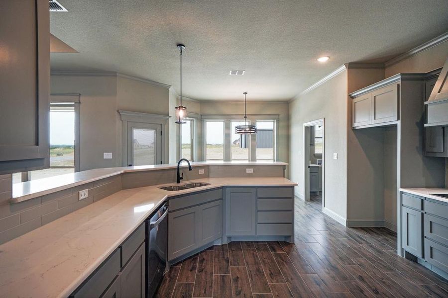 Kitchen featuring gray cabinets, sink, and ornamental molding