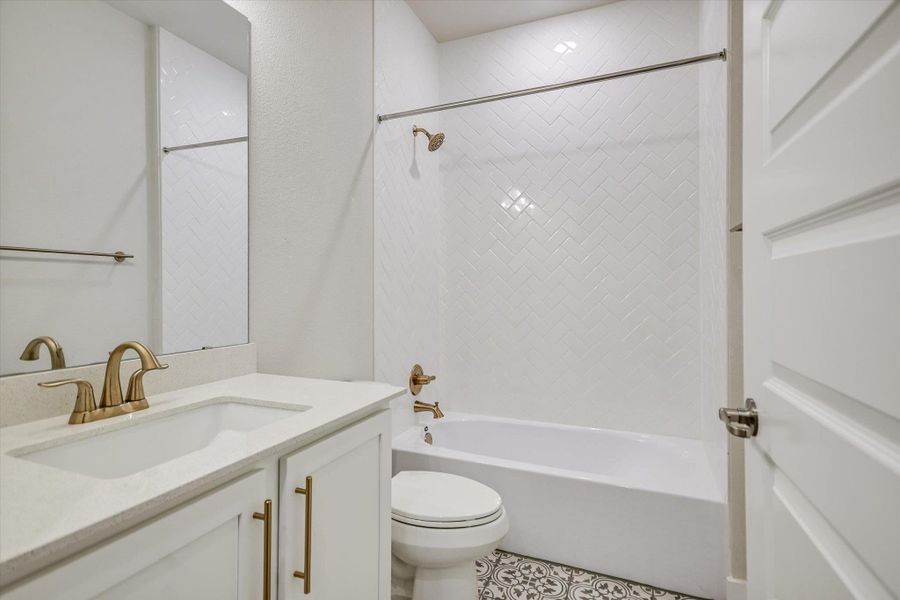Patterned floor tile and a herringbone tub surround enrich this classic bathroom layout. Patterned floor tile and a herringbone tub surround enrich this classic bathroom layout.