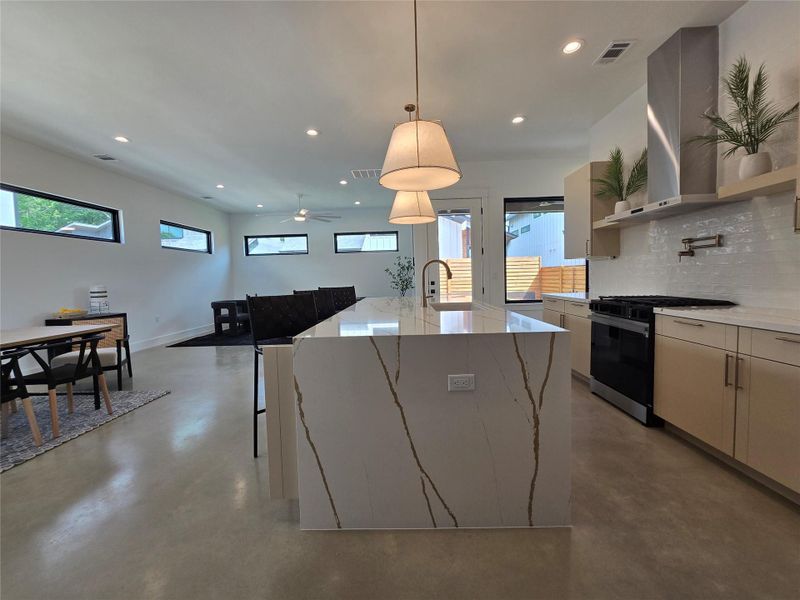 Kitchen with gas range oven, visible vents, finished concrete floors, and recessed lighting Kitchen with gas range oven, visible vents, finished concrete floors, and recessed lighting
