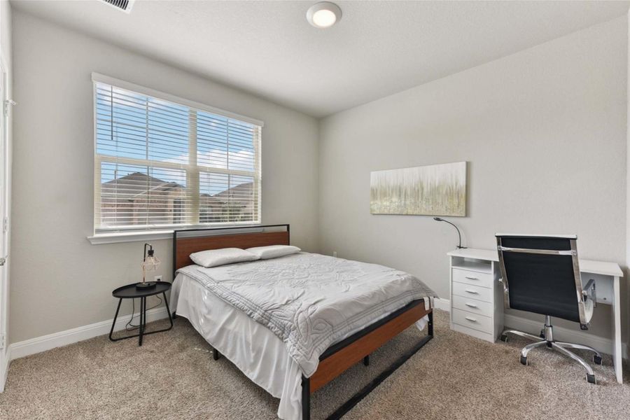 Bedroom featuring light colored carpet and baseboards Bedroom featuring light colored carpet and baseboards