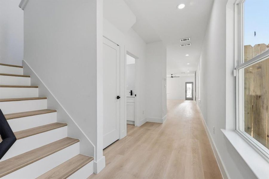 Hallway featuring recessed lighting, light wood-style floors, and stairway Hallway featuring recessed lighting, light wood-style floors, and stairway