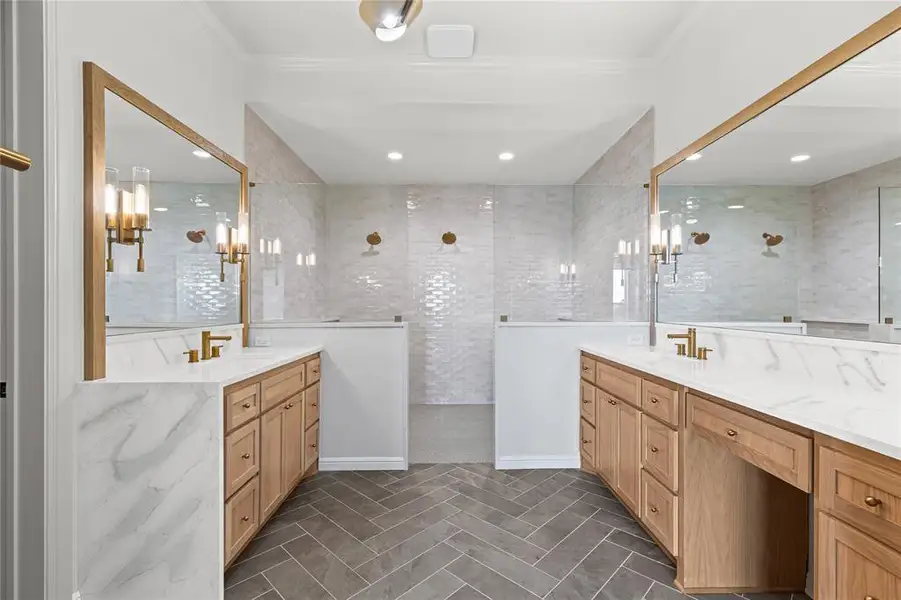 Bathroom featuring two vanities, crown molding, and a walk in shower