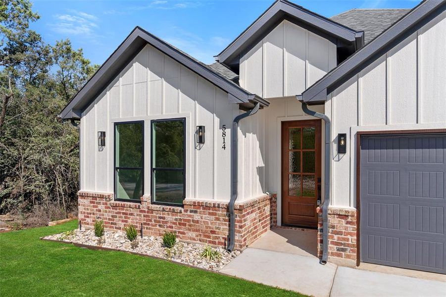 Entrance to property featuring a yard and a garage