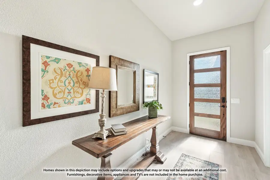 Entryway with wood console table, framed wall art, and glass-panel front door with light wood floors Entryway with wood console table, framed wall art, and glass-panel front door with light wood floors