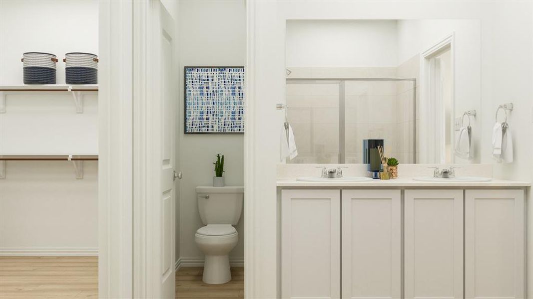 Bathroom with wood-type flooring, toilet, and double sink vanity