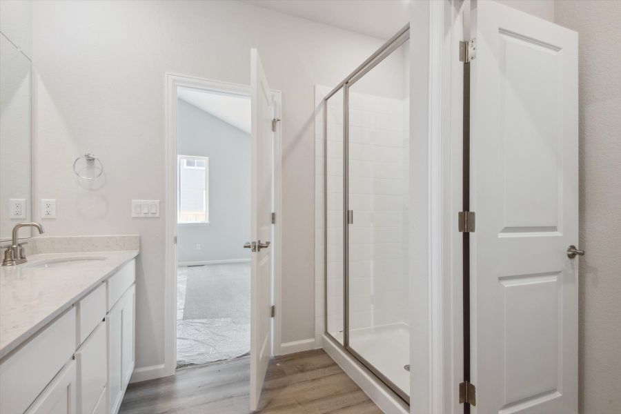 A bathroom with a shower and a glass door.