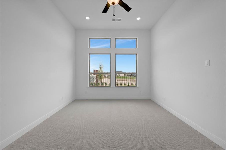 Carpeted spare room featuring a ceiling fan and recessed lighting
