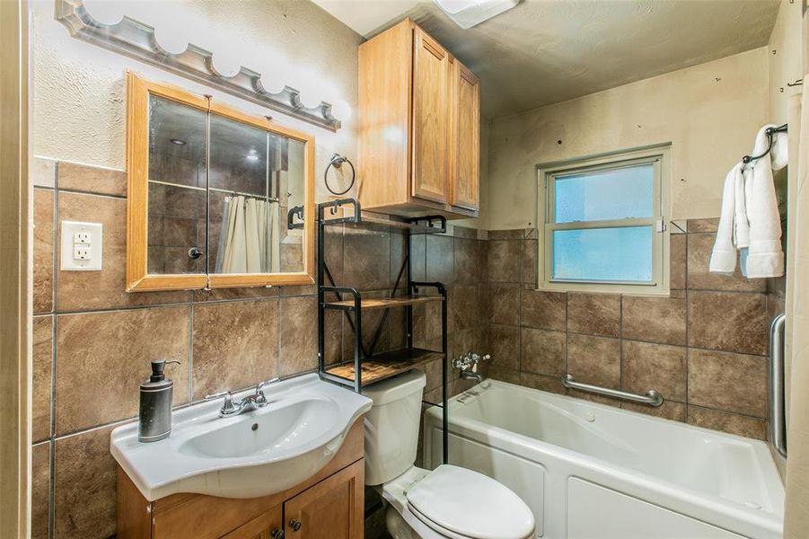Full bathroom with tile finishes, ample storage, and a walk-in tub for added convenience. Full bathroom with tile finishes, ample storage, and a walk-in tub for added convenience.