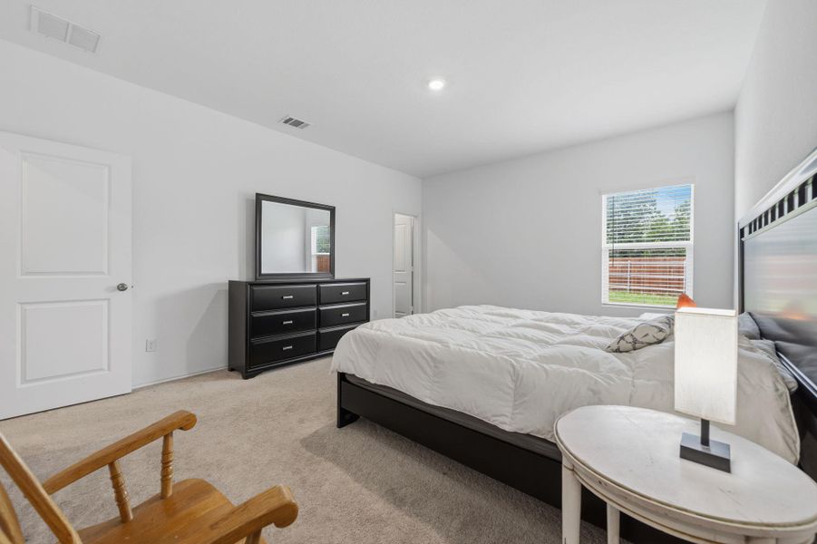 Carpeted bedroom featuring white walls, a single window with blinds, and white panel doors