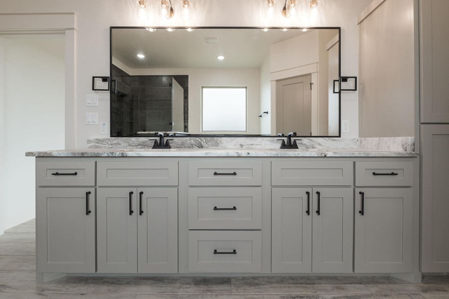 Full bathroom featuring double vanity and a stall shower