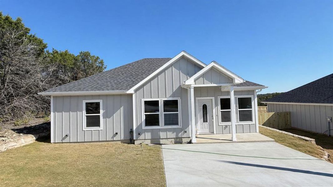 Contemporary single-story residence featuring light gray vertical siding and a dark gray shingle roof Contemporary single-story residence featuring light gray vertical siding and a dark gray shingle roof