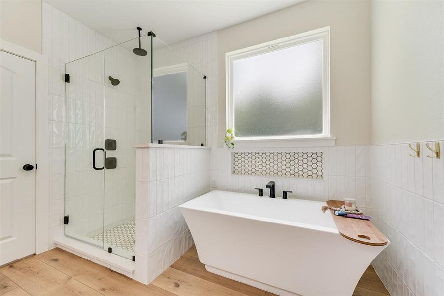 Modern bathroom featuring a freestanding soaking tub and a glass-enclosed shower