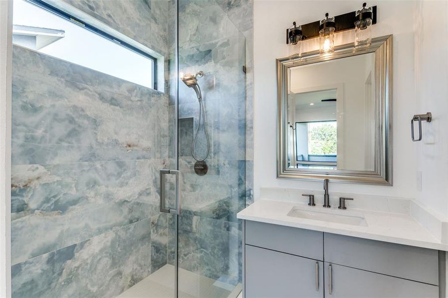 Bathroom featuring vanity, a healthy amount of sunlight, and walk in shower