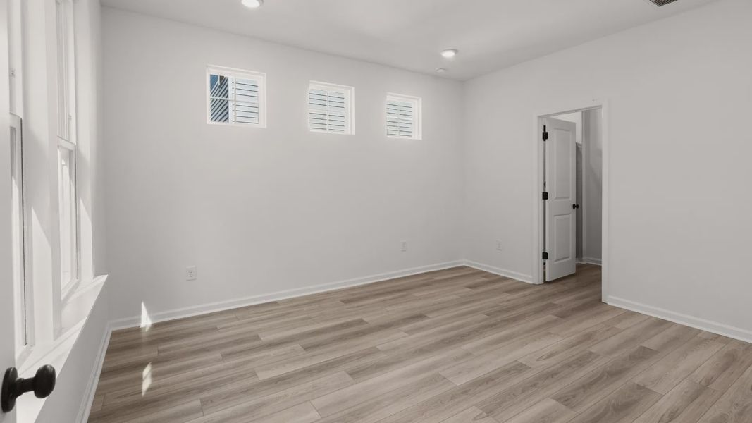 A relaxing primary suite with ample light and access to a walk-in closet