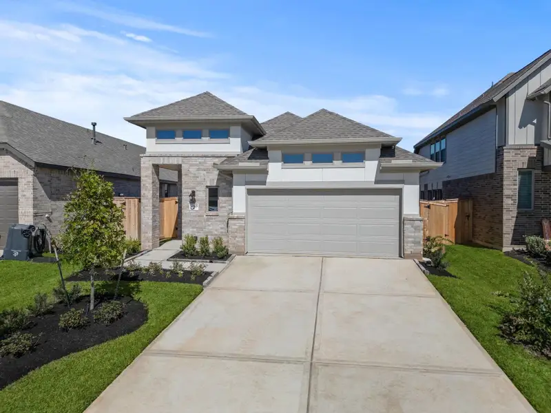 Front exterior of a new home in Grand Central Park, Conroe, TX, highlighting curb appeal (Image 2).
