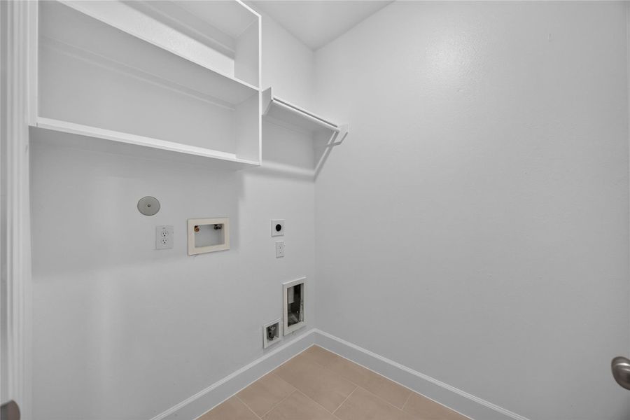 Functional Utility Room – The utility room features beautiful tile, shelving, and plenty of space for laundry and storage needs.