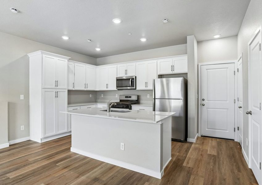 The kitchen has stainless steel appliances and plank flooring. The kitchen has stainless steel appliances and plank flooring.
