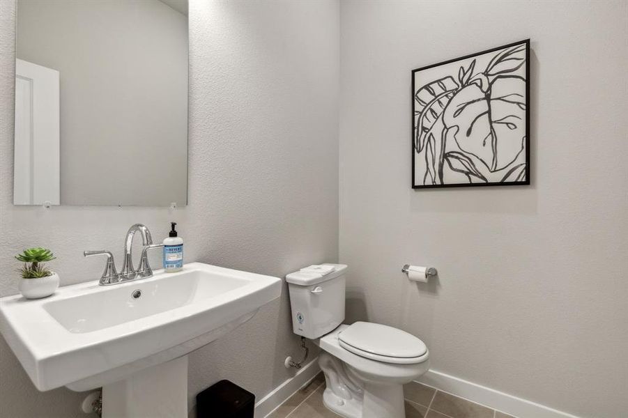 Bathroom with tile patterned flooring, toilet, and sink