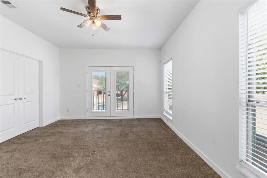 Unfurnished bedroom featuring dark colored carpet, french doors, a ceiling fan, access to outside, and a closet Unfurnished bedroom featuring dark colored carpet, french doors, a ceiling fan, access to outside, and a closet